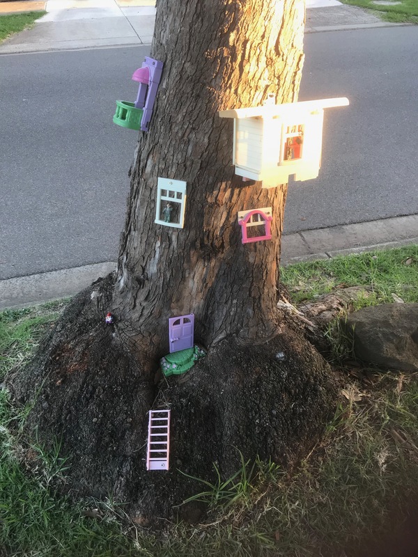 Toys on the side of a tree.