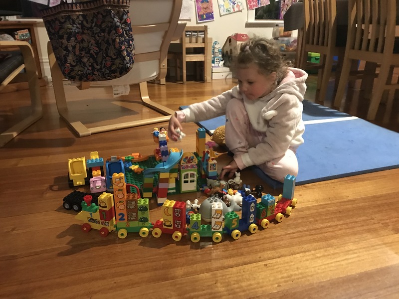 A little girl playing with Legos.