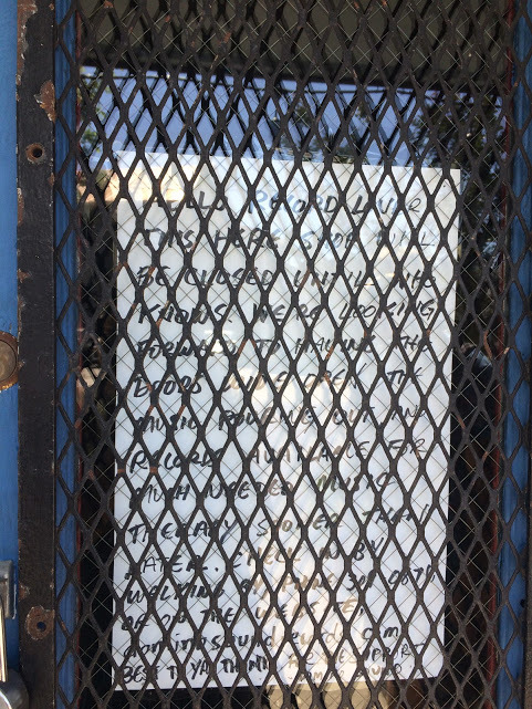 A closed sign on a grated door.