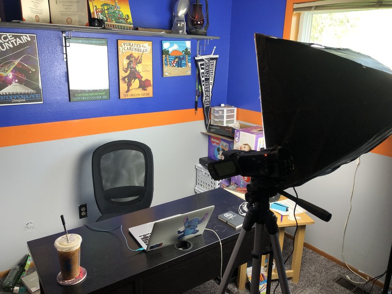 A laptop set up on a desk behind a light.