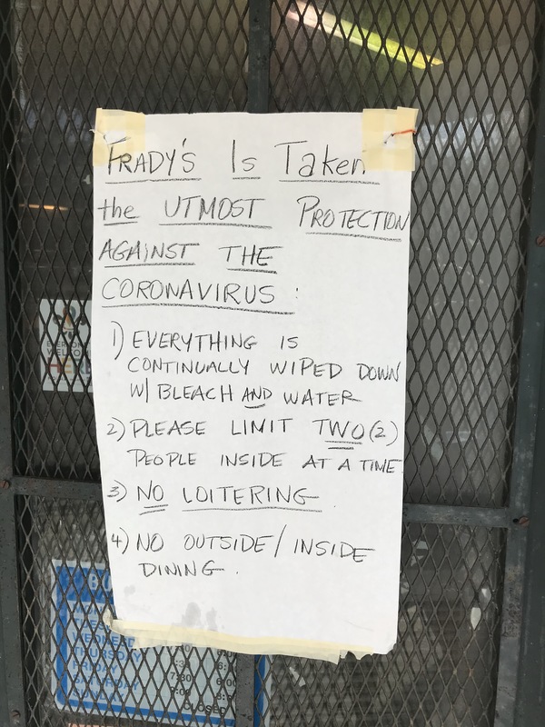 A piece of paper is taped on the front of a door to a store and says: FRADY'S IS TAKEN THE UTMOST PROTECTION AGAINST THE CORONAVIRUS: 1) EVERYTHING IS CONTINUALLY WIPED DOWN WITH BLEACH AND WATER. 2) PLEASE LIMIT TWO (2) PEOPLE INSIDE AT A TIME. 3) NO LOITERING. 4) NO OUTSIDE/INSIDE DINING.