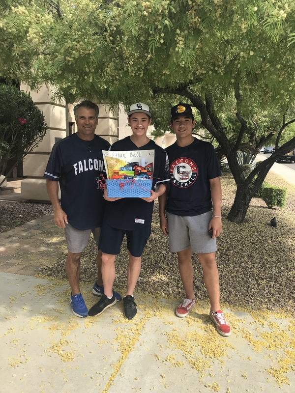 three men standing together posing with a basket full of candy