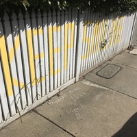 A white fence with writing that says "keep smiling".