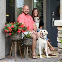 A couple posing with their dogs.