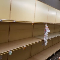An aisle in a grocery store that has empty shelves.