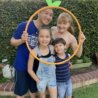 Two adults and two children holding an outline of a pumpkin.