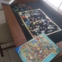 A table that has a puzzle being put together in progress.