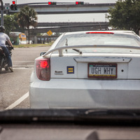 A white Toyota Celica with a license plate that says "Ugh Why" on it.