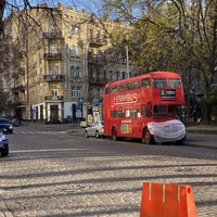A double decker bus with a mask on the front.