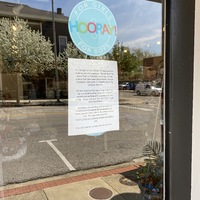 A sign in a store window detailing their COVID-19 precautions.