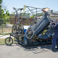A person putting scrap in a metal cage.
