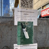A walkie-talkie hanging from a wooden beam.