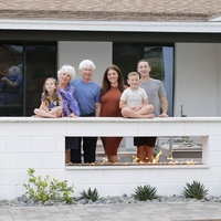 A family posing for a picture in front of a house.