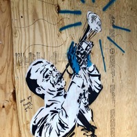 Street art of a man playing an instrument.
