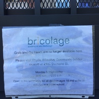 A paper sign on a grated door.