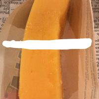 This is a picture taken of an orange ice cream pop in a wrapper.