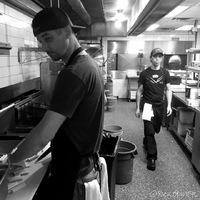 Two men in a kitchen working.
