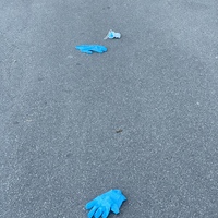 Two gloves and one mask on the ground.
