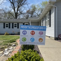 A yard sign with COVID-19 protocols.