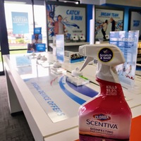 A bottle of clorox that is on top of a display case for phones that is empty.