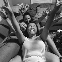 This is a picture taken of three women sitting on a couch and laughing.