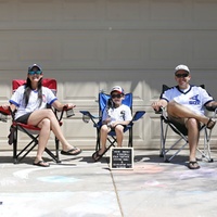 A family sitting on lawn chairs.